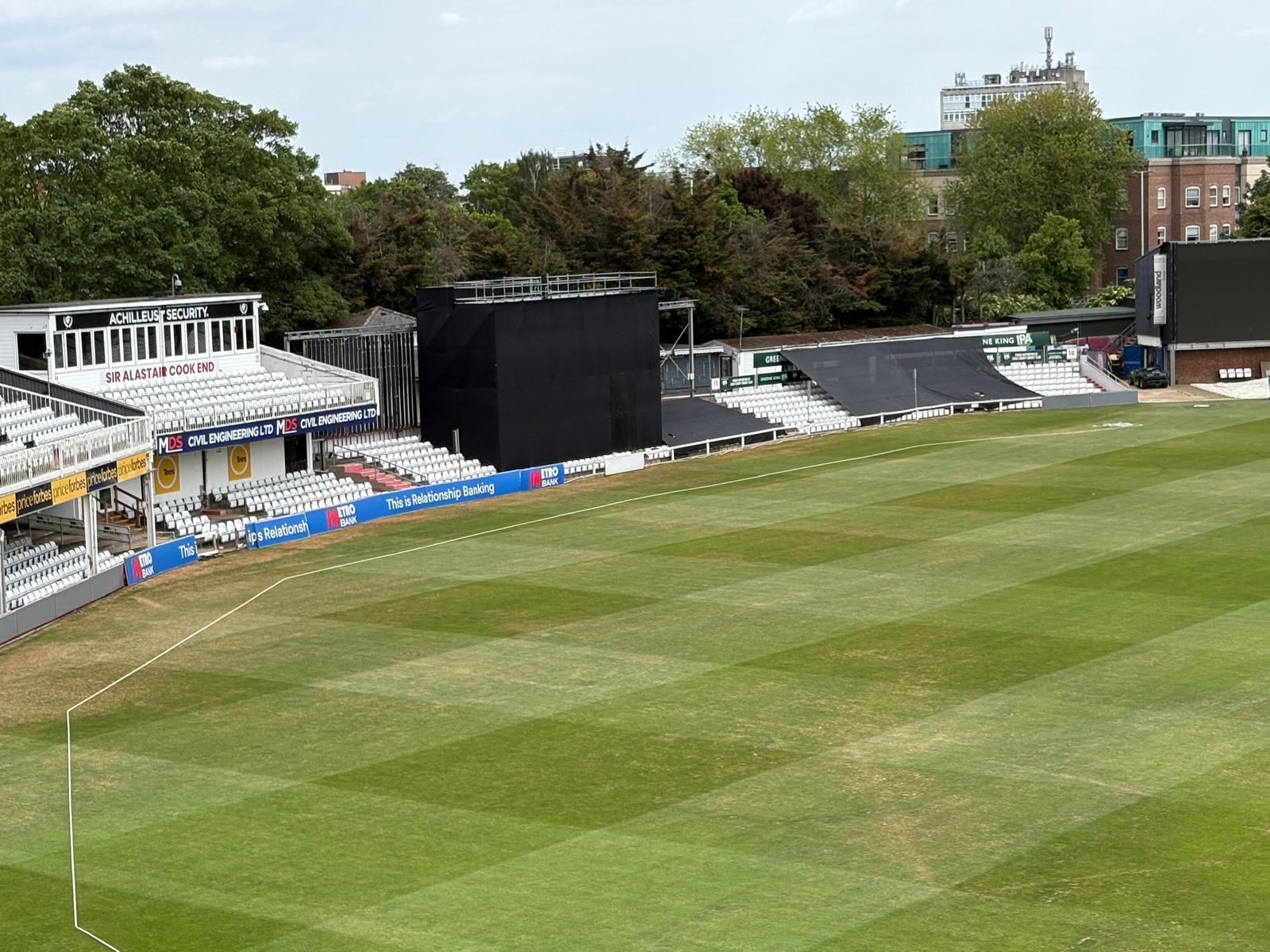 Black event netting covering spectator seating at a cricket ground