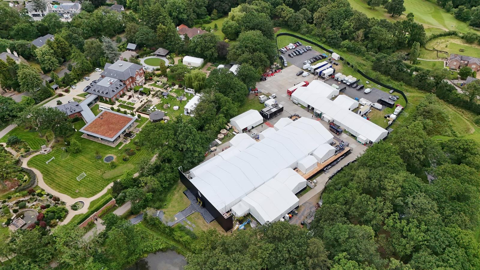 Aerial view of white event marquees and temporary structures at a UK country-house venue
